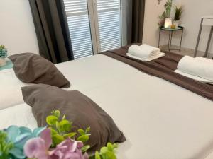 a bed with two pillows and a mirror on it at Apartments Ana & Ita in Novalja