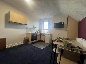a room with a kitchen with a table and a tableablish at Stylish 1 bedroom Flat central Skegness F9 in Skegness