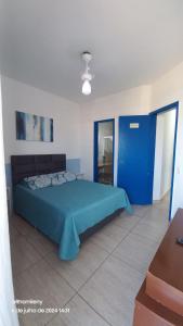 a bedroom with a blue bed and a blue door at Cabo Frio frente Mar 03qt in Cabo Frio