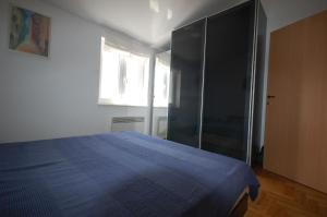 Schlafzimmer mit einem blauen Bett und einem Glasschrank in der Unterkunft Apartment Vesna in Porat