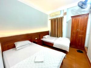 a room with two beds and a laptop computer on it at Tuân Thuỷ hotel đảo Quan Lạn in Làng Liễu