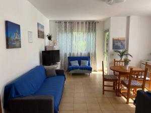 a living room with a blue couch and a table at Spacious apartment with the private terrace in Arona
