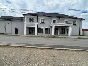 a white building on the side of a road at Luxeva Events Hotel in Drăgăneşti-Olt