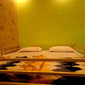 リシケーシュにあるShreeji Inn Homestayの緑の壁の部屋にベッドが2つある