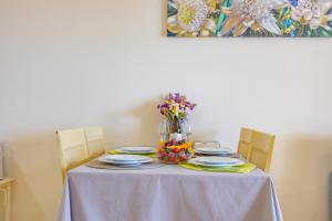 una mesa con platos y flores encima en Apartment of Joy Piscina Aparcamiento, en Calpe 32 fotos más