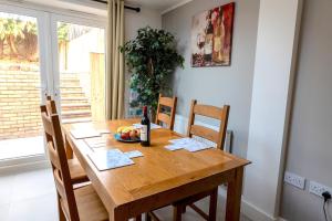 a dining room table with a bottle of wine and a bowl of fruit at Peakstone House in Woodhouse
