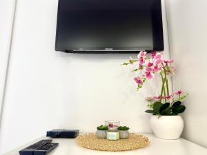 a desk with a monitor and a keyboard and flowers at Apartments Ana & Ita in Novalja
