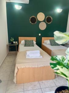 two beds in a room with green walls and mirrors at Apartments Ana & Ita in Novalja
