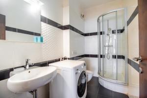 a white bathroom with a sink and a toilet at Mamaia Lake View Apartament in Mamaia +17 photos
