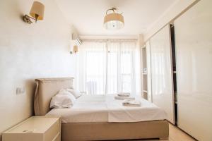 a bedroom with a bed and a window at Mamaia Lake View Apartament in Mamaia