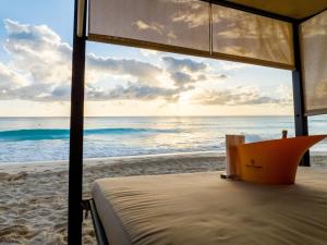 a view of the ocean from a bed on the beach at Paradisiaca Suite Cancun - BEACH CONDO - 4PX in Cancún