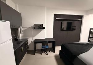 a bedroom with a desk and a bed and a refrigerator at Quitinete Inteligente No Centro Unidade 03 in Presidente Prudente +15 photos