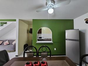 a kitchen with a green wall and a ceiling fan at Sensity Home Casa Verona Novedosa Céntrica y Linda in Tehuacán