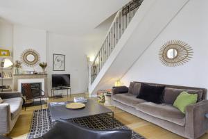 a living room with a couch and a table at Maison Nova - Welkeys in Le Bouscat