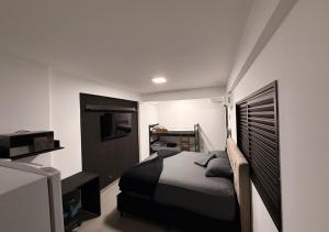 a bedroom with a bed and a desk in it at Quitinete Inteligente No Centro Unidade 03 in Presidente Prudente