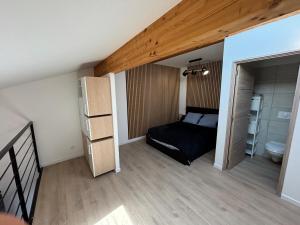 a small bedroom with a bed and a bathroom at LA MARANA - 1 minute des plages - Proche BASTIA AEROPORT - T2 entièrement neuf avec cuisine équipée in Lucciana