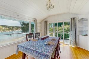 a dining room with a table and a large window at Rosewater Cottage in Eagledale