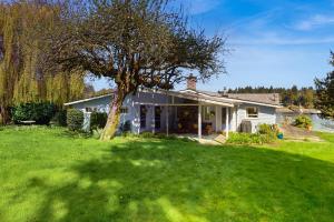 a white house with a tree in the yard at Rosewater Cottage in Eagledale