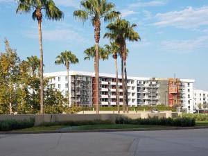 a large apartment building with palm trees in the background at Penthouse Dreams in Irvine