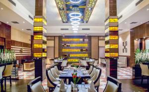 马图拉Hotel Abhinandan的一间有桌椅的餐厅
