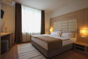 a bedroom with a large bed and a window at Sarajevo Daily Apartments in Sarajevo
