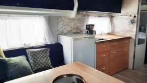 a kitchen with a refrigerator and a table in a caravan at Caravan De Rozenbottel in Hensbroek