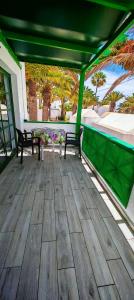 a patio with two benches and a table on a deck at La casa di marcos in Costa Calma