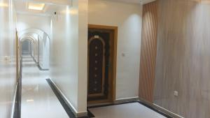 a hallway with a wooden door in a building at Arabian Sands Hotel فندق الرمال العربية in Haymāʼ