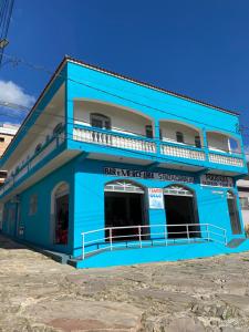 a blue building with a balcony on top at Pousada sagrada família in São Thomé das Letras