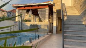 a house with a swimming pool next to a staircase at Boutique Hotel Alegria in Supetar