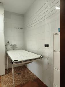 a white tiled room with a bed in it at O Piñón in Santa Cristina de Cobres