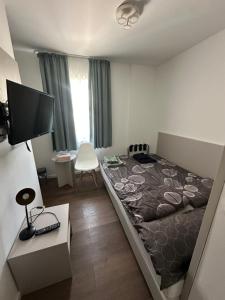 ein Schlafzimmer mit einem Bett und einem Fernseher darin in der Unterkunft Möbiliertes Apartment in Hamburg