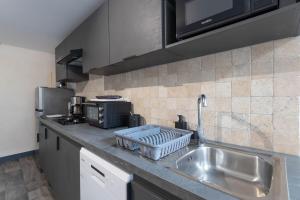 eine Küche mit Spüle und Arbeitsplatte in der Unterkunft Le Château Fort 16 in Albertville + 1 Foto