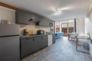 eine Küche mit einem Kühlschrank und einem Tisch mit Stühlen in der Unterkunft Le Château Fort 16 in Albertville