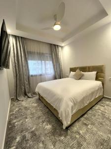 een slaapkamer met een groot bed en een raam bij Lux Rentals 2 chambres - CaboNegro in Cabo Negro