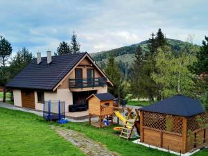 a small house with a playground and a slide at Chata Junáčik Oravice in Oravice
