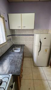 a kitchen with a white refrigerator and a sink at Casa centro in Patagones