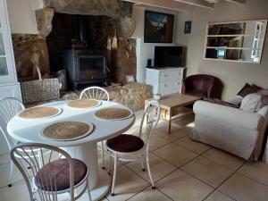 a living room with a table and chairs and a fireplace at Kelerdut Plage in Plouguerneau
