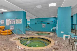 a hot tub in a room with blue walls at Modern & Updated Oceanview Studio! Sleeps 4! Landmark 523 in Myrtle Beach