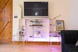 a tv sitting on top of a stand with two chairs at Ralph's Barn in Newport