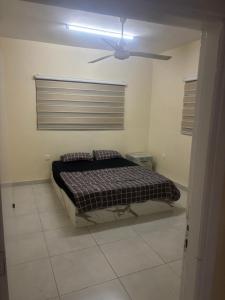 a bedroom with a bed and a ceiling fan at Bubbles in Jurf ad Darāwīsh