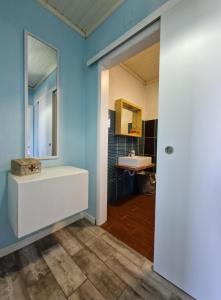 Un baño con un lavabo blanco y un espejo. en Casa do Baixio, en Faja Grande 10 fotos más
