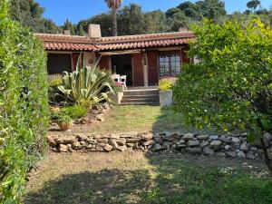 a house with a stone wall in front of it at Petite maison provençale pour 4 personnes in Bormes-les-Mimosas