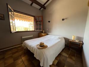 a bedroom with a bed with a hat on it at Petite maison provençale pour 4 personnes in Bormes-les-Mimosas
