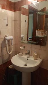 łazienka z białą umywalką i lustrem w obiekcie Guesthouse Kallisti w mieście Anilio Pelion