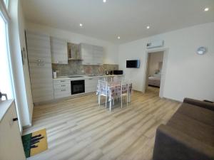 a kitchen and living room with a table and chairs at Il Sogno di Francesca in Alghero