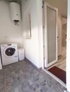 lavadero con lavadora y puerta en Il Sogno di Francesca, en Alghero