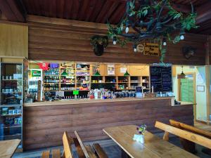 a restaurant with a bar with wooden walls and tables at Schronisko PTTK Pod Muflonem in Duszniki Zdrój +14 photos