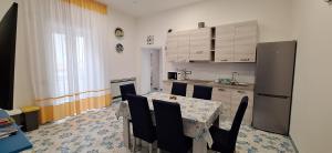 a kitchen with a table with chairs and a refrigerator at Mamma Giovanna in Maiori