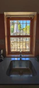 eine Spüle in einer Küche mit einem Fenster darüber in der Unterkunft Villa townhouse Calvario in Pollença